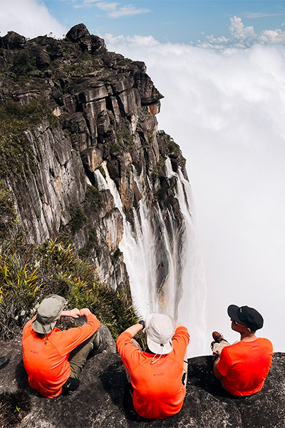 group sitting on top of waterfall