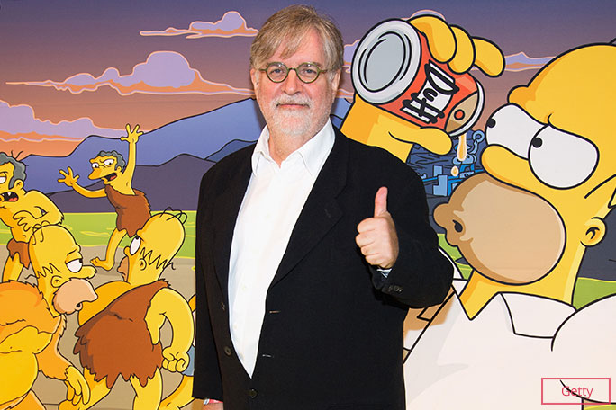 Matt Groening in front of simpsons poster