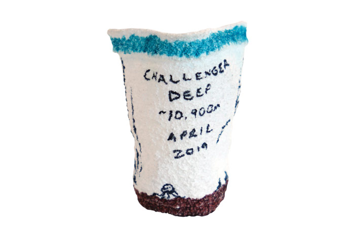 A polystyrene cup crushed to the size of a shot glass by the immense pressure during the descent to Challenger Deep