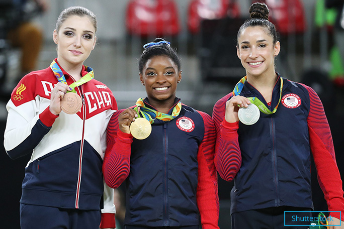 Simone shows off her gold medal for the women's individual all-around final at Rio 2016. She is flanked by compatriot Alexandra Raisman (silver) and Aliya Mustafina (bronze) of Russia