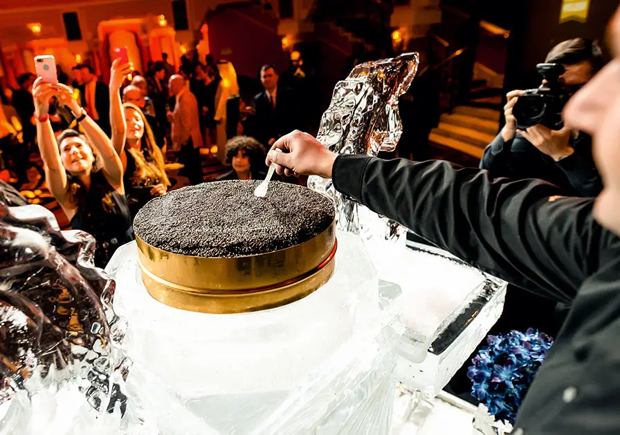 Man getting filmed cutting a cake