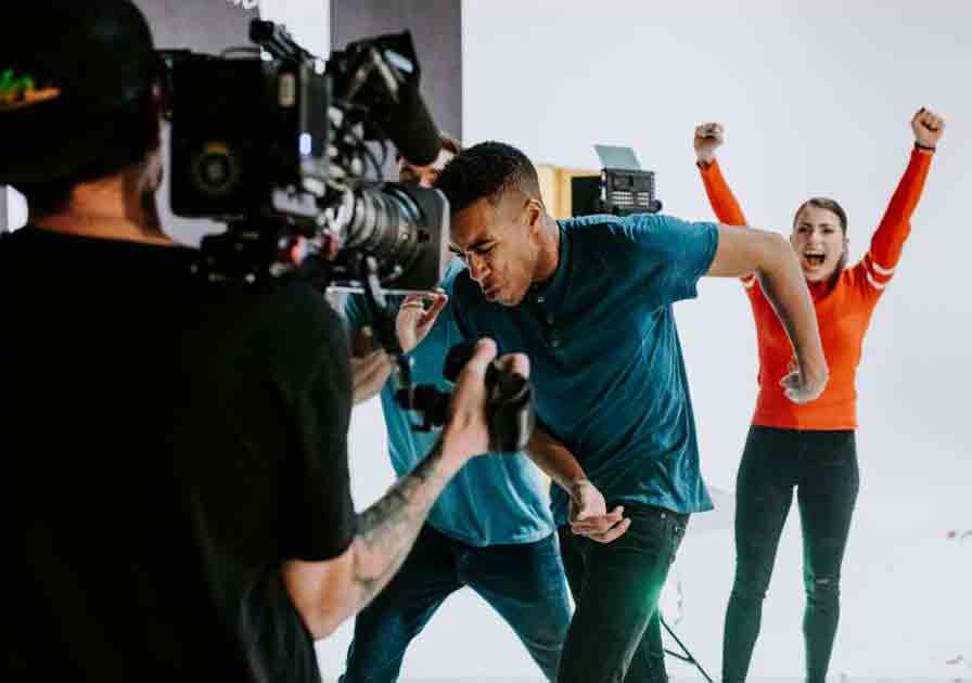 man getting filmed and woman celebrating in the background