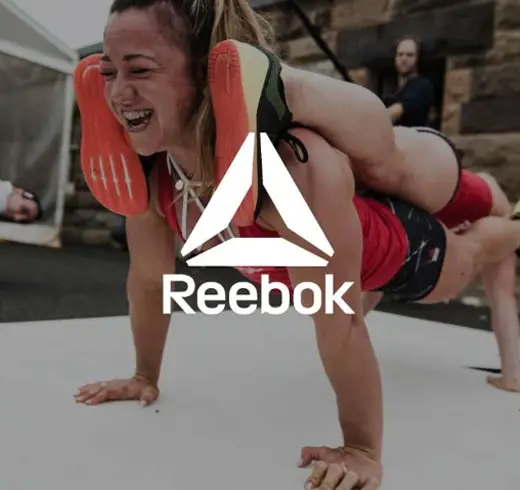 reebook - one woman doing a plank on top of another woman