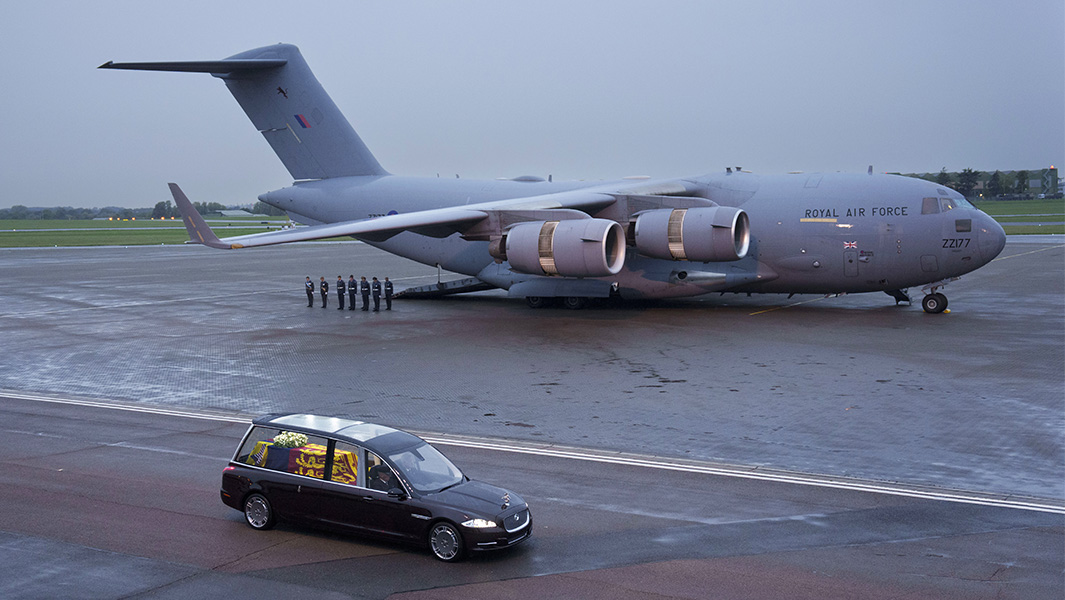 Queen Elizabeth II coffin in the royal hearse with RAF aircraft and pallbearers in background