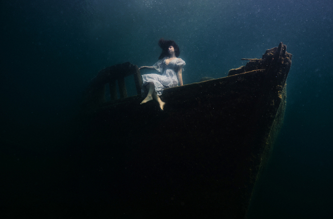 model sitting on shipwreck