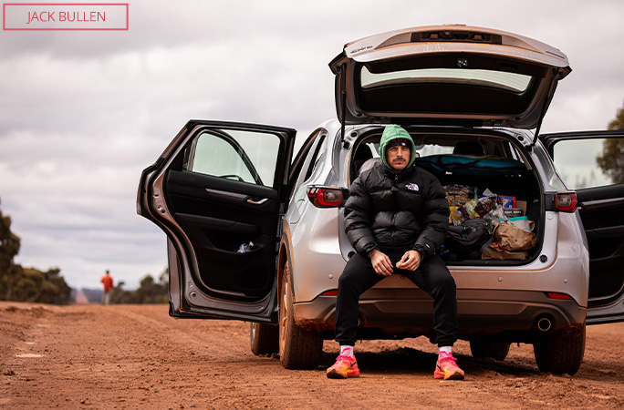 Chris sits in the trunk of the support car