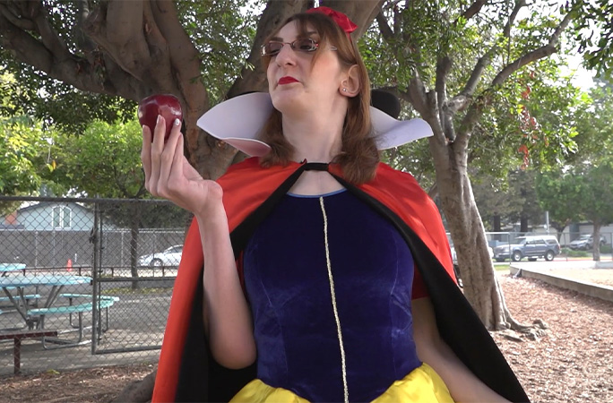 Rumeysa dressed as Snow White and holding an apple