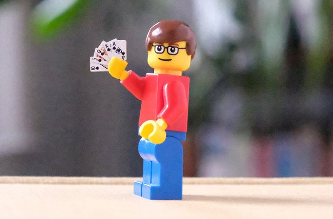 Lego man holding smallest pack of playing cards