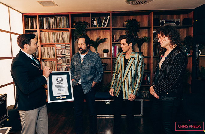 Guinness World Records Adjudicator Will Munford presents The Killers with a certificate