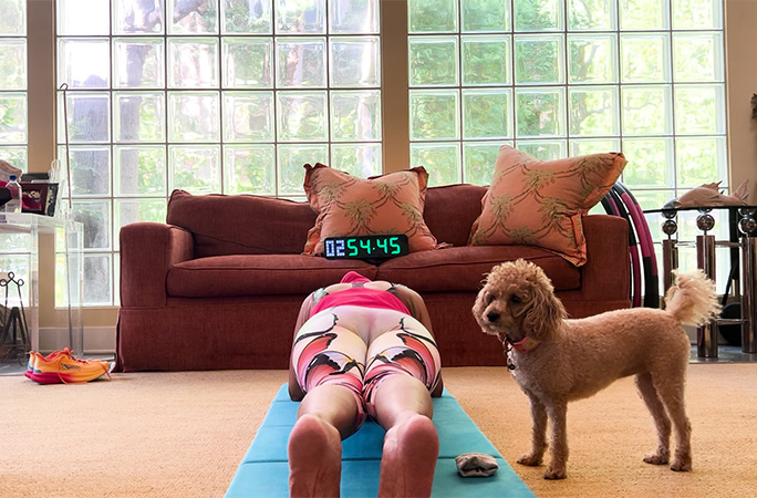 Annie planking with dog Carmen by her side