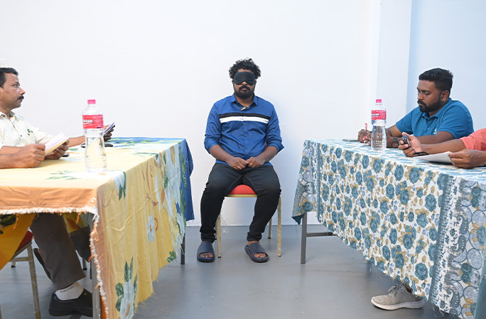 Deepu sitting blindfolded between witnesses