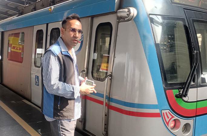 Shashank standing next to a train