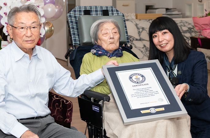 Tomiko receiving GWR certificate at home