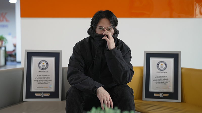Zhang sitting with his GWR certificates