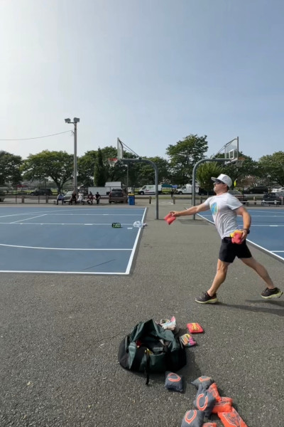 Man tosses a bag into a cornhole while blindfolded