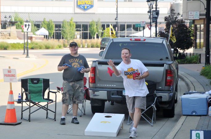 Partners throw bags in a cornhole marathon