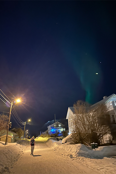 Gill running under the northern lights dressed as a polar bear