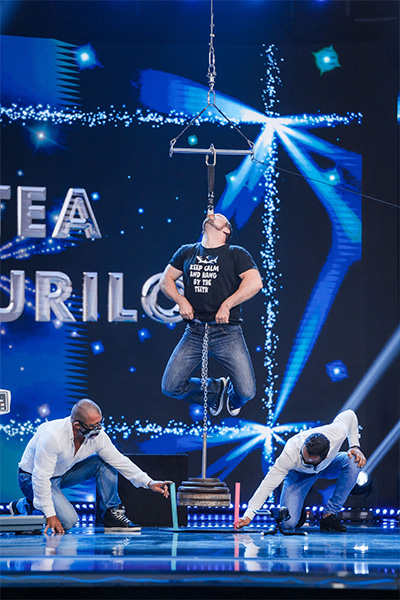 Leonardo holding weight while hanging by his teeth