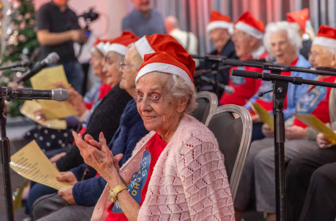 A member of the oldest choir smiles as she sings