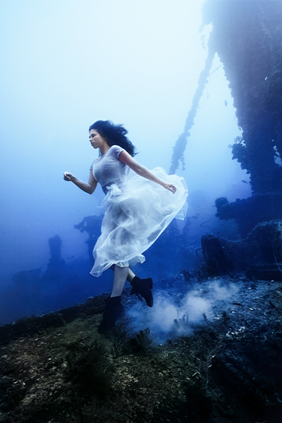 Model posing underwater, from the side