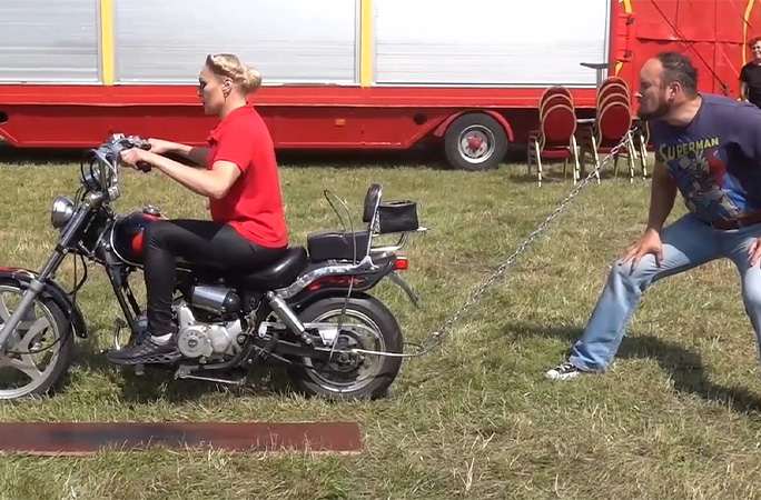 Vita riding a motorcycle while Leonardo restrains it with his beard