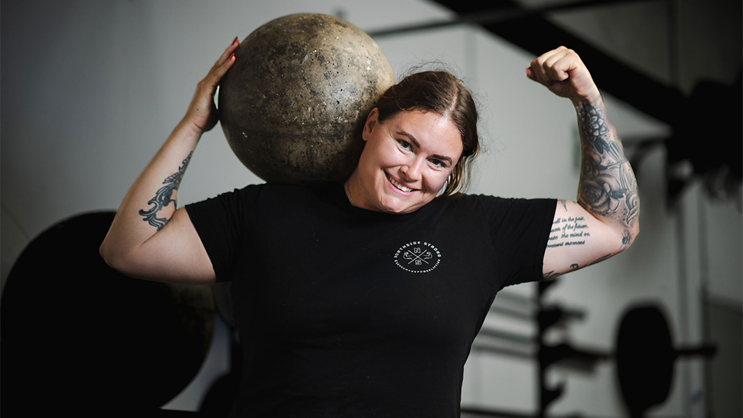 Nicole Genrich posing with an Atlas stone on her shoulder