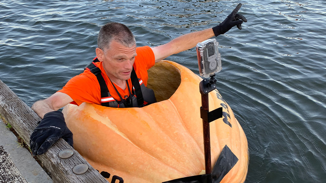 Gary sitting in his pumpkin boat and sailing it