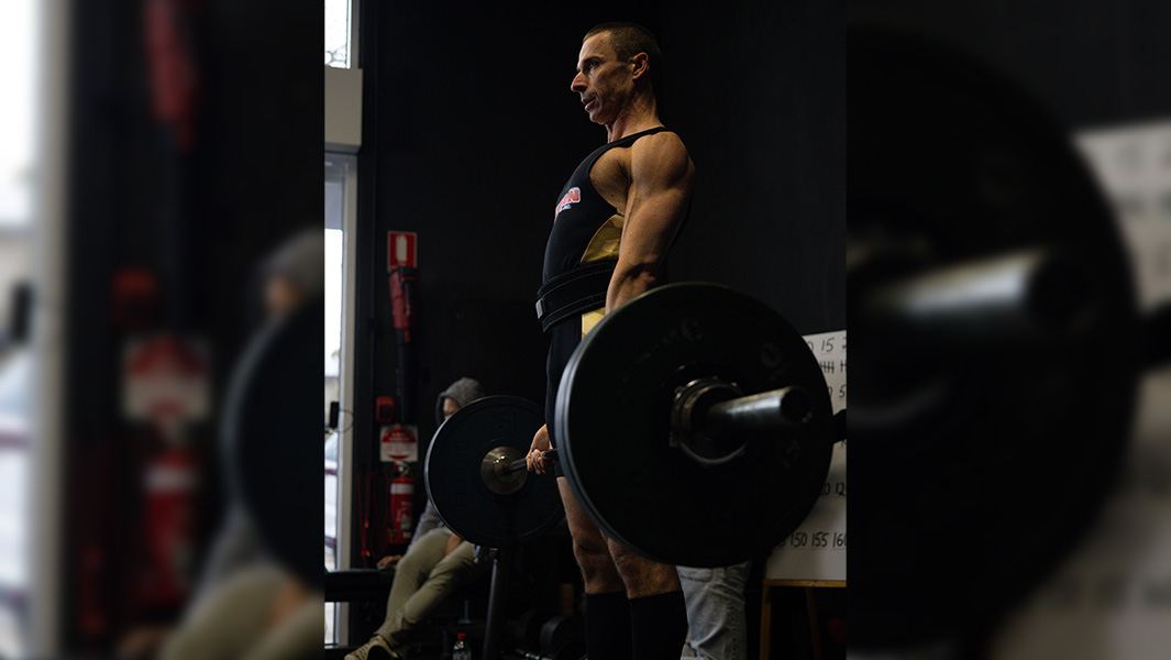 split image of Maciej lifting weights and his torn hands