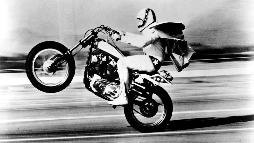 Evel Knievel pulling a wheelie on his motorbike