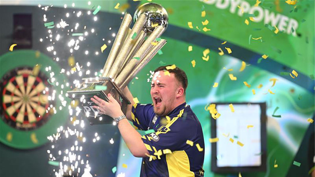 Split image of Luke Littler holding a trophy and Paul Lim smiling whilst doing the peace sign with his fingers