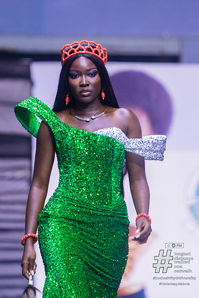 Ololade walking the catwalk in a green outfit
