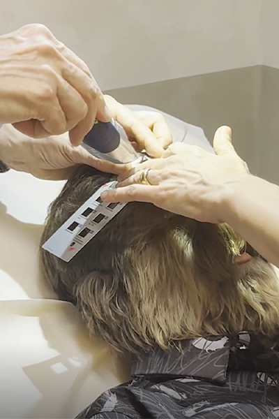 A doctor shaving some hair off Lalit's face