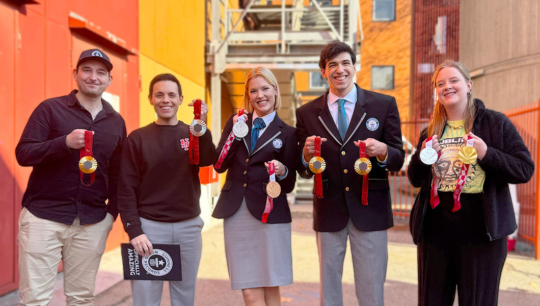 Lo Show Team smiling in the sun with orange background