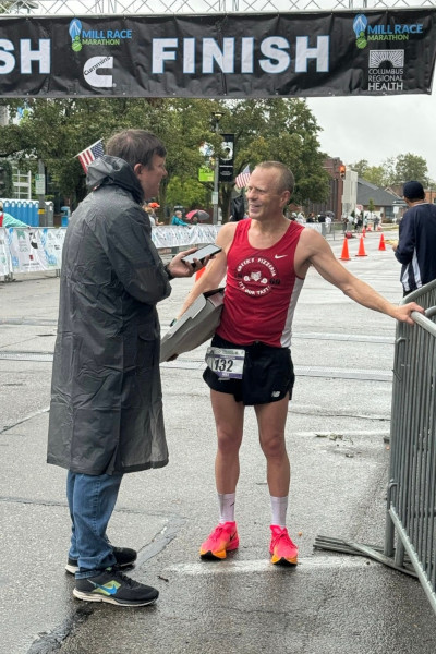 Mike Cole talking to a race attendant at the finish line