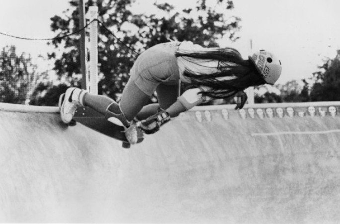 Black and white image of Judi skating around a pool