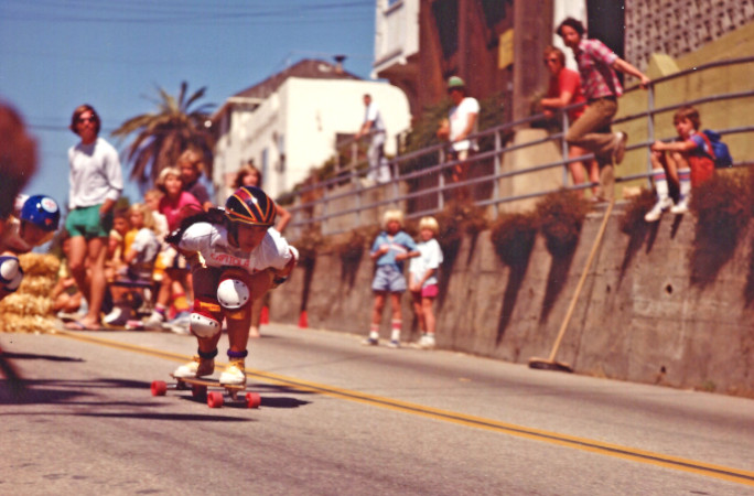 Judi racing a boy down a hill