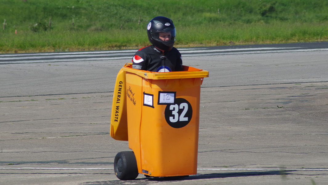 split image of a man standing on a wheelie bin and sitting in one