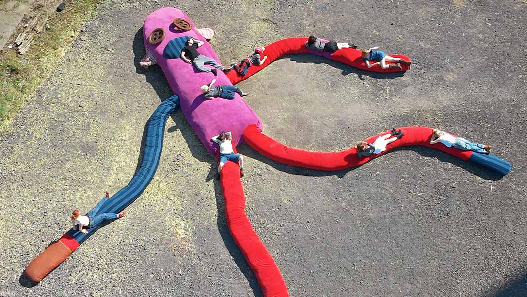 split image of largest sock monkey sculpture from above and close up