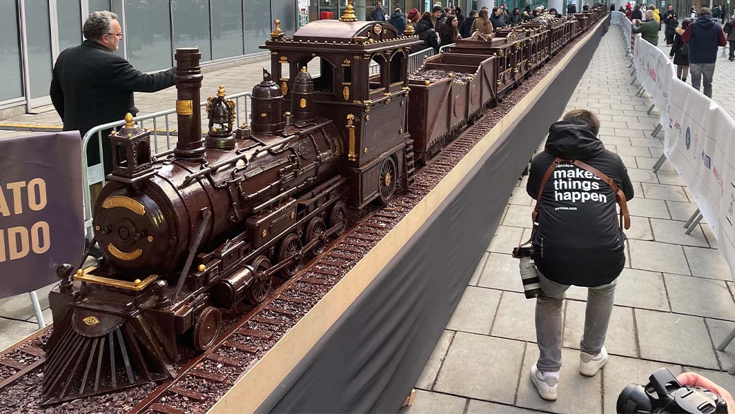 chocolate train sculpture seen in entirey with a crowd gathered round