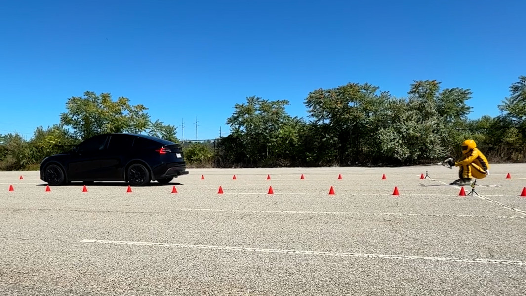 Johnny being towed in skis across a parking lot