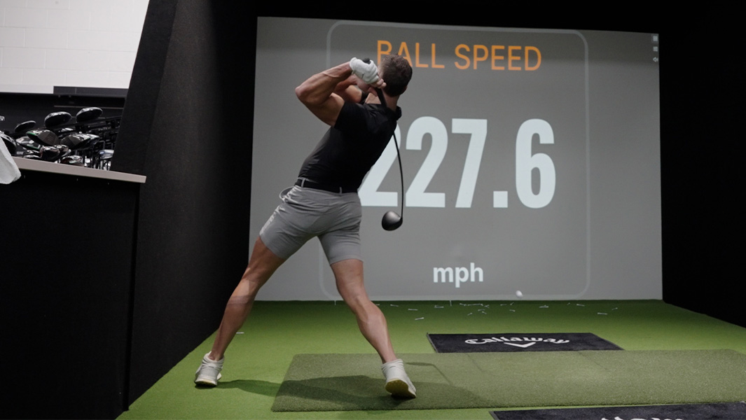man hitting golf ball at screen to measure speed