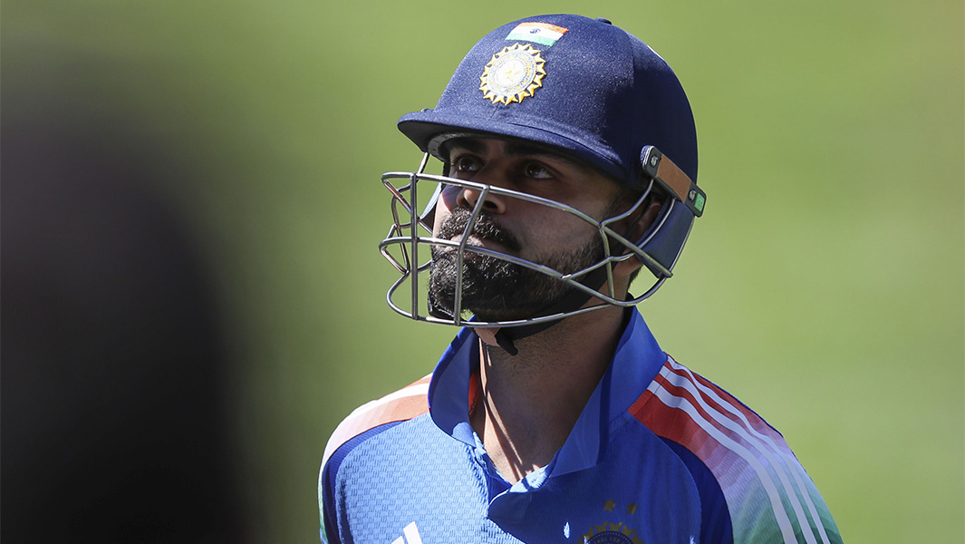Virat Kohli on the field wearing a helmet