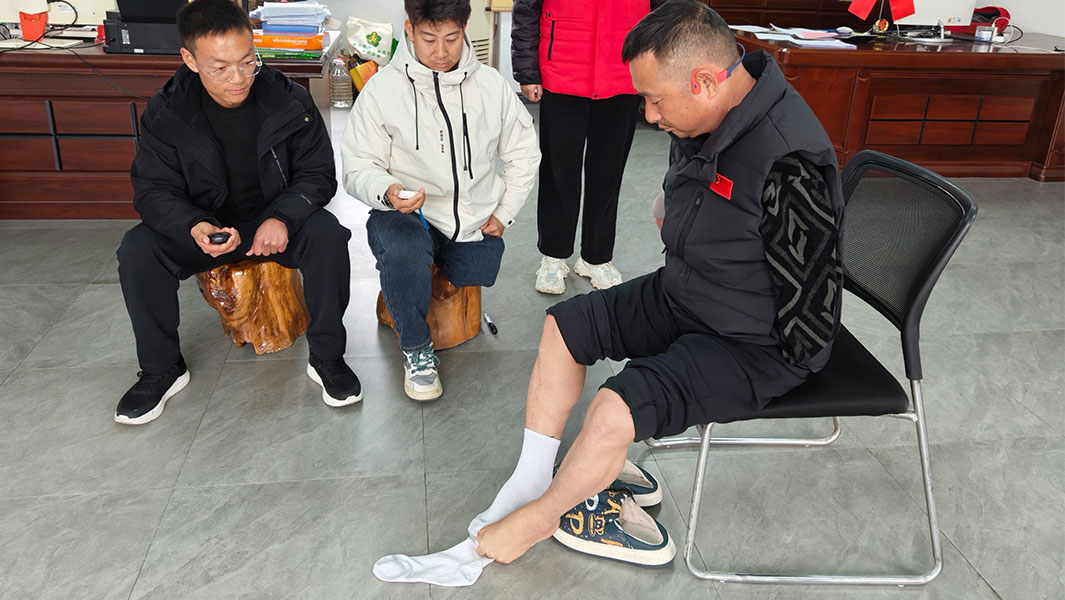Li Fengqiang pulling on socks with his feet