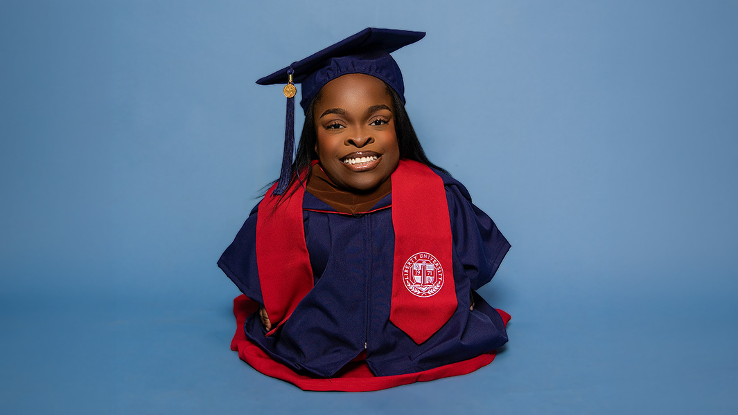 Wildine dressed in a graduation cap and gown