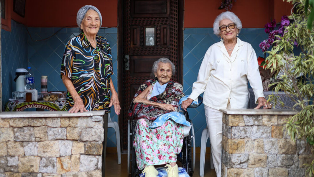 Three sisters posing together after a breaking a record with their combined age