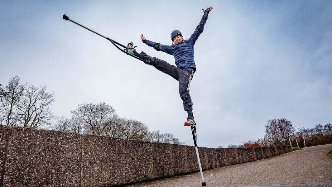 Jonathan kicking his legs out and celebrating with his stilts on