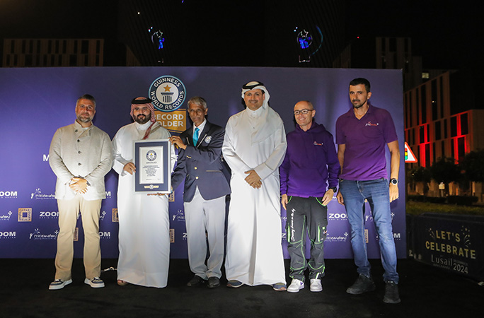 a group of people with official adjudicator prav patel being awarded the guinness world records certificate
