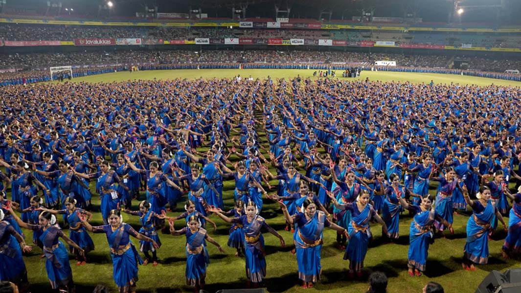 split image of dancers wearing blue saris and a guinness world records certificate presentation