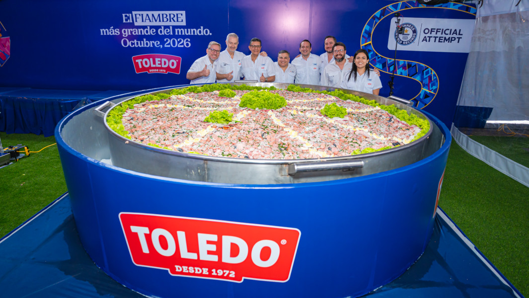 The organizers standing next to the largest fiambre salad