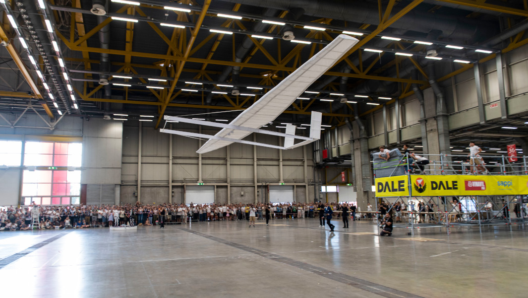 The largest paper plane mid-flight in front of the crowd